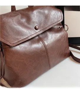 Close-up of soft brown leather texture and drawstring detail on the bucket bag