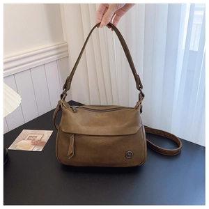 Detailed view of a brown vintage shoulder bag featuring dual zippers and metal logo charm