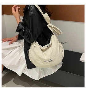 Détail du sac besace hobo avec grand nœud sur la bandoulière et logo MUCAIXI