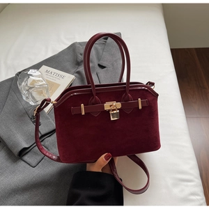 Détails du sac en daim bordeaux avec cadenas doré et coutures de haute précision