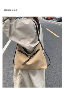Detailed view of large khaki suede tote bag with black leather straps and gold buckle