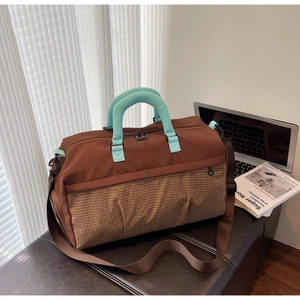 Brown and checkered duffel bag with mint blue handles and detachable shoulder strap