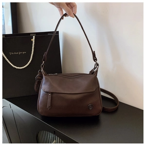 Detail view of coffee brown faux leather square bag with visible litchi grain texture