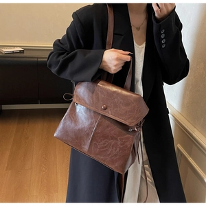 Detail view of vintage brown textured leather backpack with flap closure and drawstring