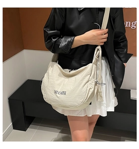 Détail du sac croissant en nylon blanc cassé avec logo MUCAIXI et cordon de serrage chic
