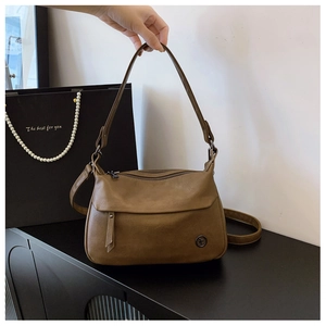 Detail view of brown vintage half-moon bag with lychee texture and dual shoulder straps