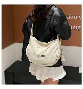 Détail du sac bandoulière demi-lune blanc cassé avec fermeture éclair et logo MUCAIXI