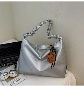 Sac hobo argenté avec poignée froncée et détail de breloque ours en peluche marron