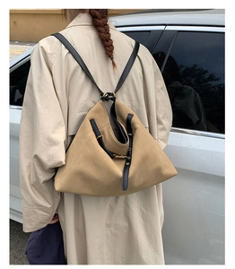 Detail of khaki large tote bag featuring triangle fold design and black leather straps