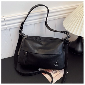 Detail of a black multi-layer crossbody bag with textured leather and silver logo
