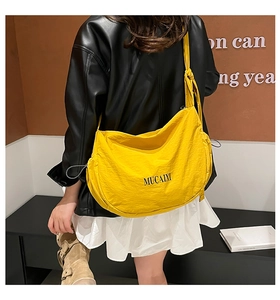 Détail d'un sac bandoulière croissant en nylon jaune vif avec large bandoulière