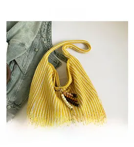 Interior view showing capacity of yellow striped knit tote bag with beaded tassel