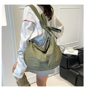 Sac bandoulière demi-lune vert olive en nylon avec large bandoulière à nœud au porté