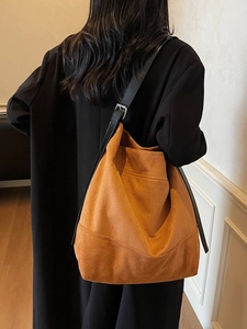 Brown suede hobo bag with adjustable black leather strap shown on model for daily style