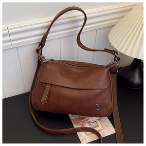 Detail of dark brown lychee grain PU leather bag with multi-zipper layers and straps