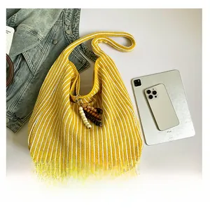 Detailed knit bag texture with yellow-white stripes and decorative wooden bead charm