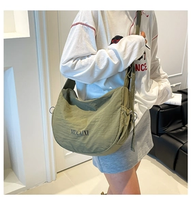 Détail du sac hobo en nylon vert olive avec texte logo et large bandoulière réglable