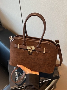 Sac coquille en daim marron foncé mat avec fermoir doré et bandoulière réglable