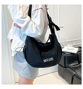 Détail du grand sac hobo noir avec bandoulière large réglable et cordon latéral