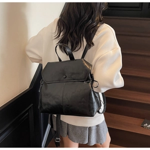 Macro detail of high-quality black leather backpack with drawstring and flap closure