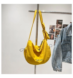 Gros plan du tissu en nylon jaune froissé avec imprimé MUCAIXI et détails de cordon décoratif