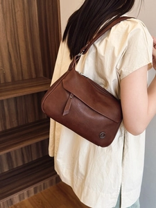 Retro brown leather crossbody bag with metal logo, vintage style for women