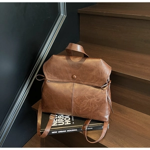Close-up of vintage brown PU leather backpack texture on wooden stairs with books