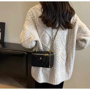 Quilted tweed crossbody bag with gold chain strap shown on model in white sweater