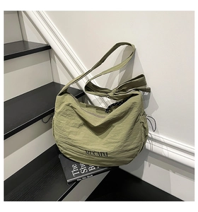 Détail du sac bandoulière vert herbe en nylon avec cordon réglable et logo MUCAIXI
