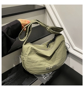Détail du sac croissant vert matcha montrant le nœud de la bandoulière et le nylon plissé