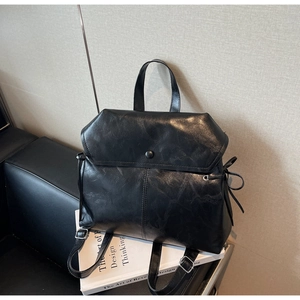 Detail of vintage black bucket bag with matte leather texture and drawstring closure
