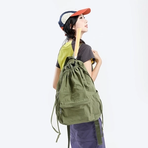 Detail of army green nylon backpack showing drawstring closure and water-resistant fabric
