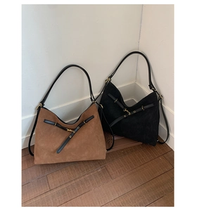 Detail of suede hobo bags in brown and black with leather straps and gold hardware