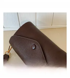 Dettaglio della pelle marrone cioccolato e finiture dorate della borsa a tracolla