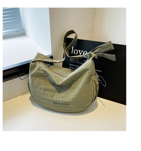Détail du sac à main en nylon vert clair avec texture plissée et sangle à nœud réglable