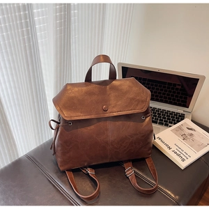 Detail view of brown leather backpack texture with magnetic flap and drawstring sides