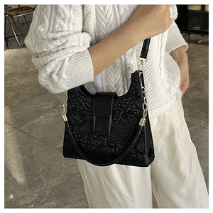 Detail of black animal pattern shoulder bag featuring a sleek square magnetic buckle