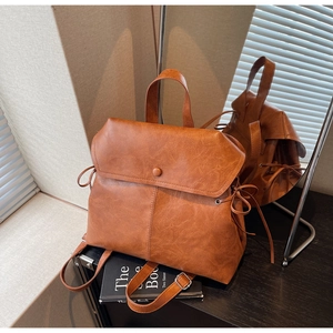 Detailed close-up of retro caramel brown faux leather backpack with mirror reflection