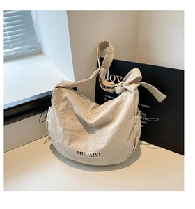Détail du sac à main en nylon blanc cassé avec cordon latéral et logo MUCAIXI