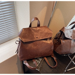 Close-up of vintage brown leather backpack texture with adjustable straps and metal buckle