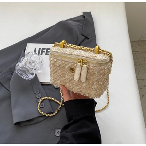 Detail of tweed crossbody bag with double zipper and golden flower metal hardware