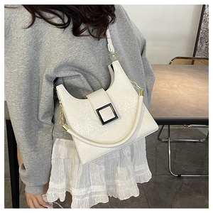 Detail of white textured crocodile skin crossbody bag with bold square metallic buckle