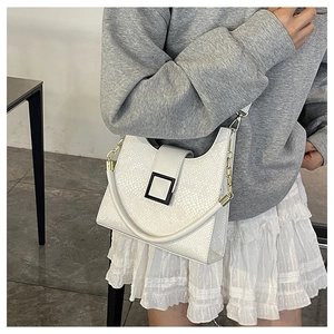 Detail of white snakeskin texture faux leather underarm bag with black square buckle