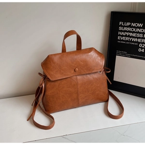Detailed view of brown retro leather backpack with drawstring texture and magnetic closure