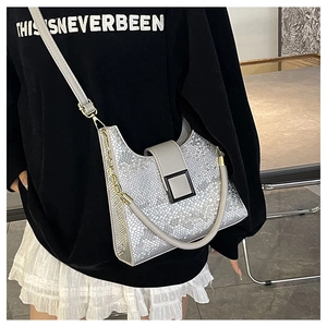 Close-up of silver snakeskin texture on a luxury shoulder bag with metallic finish