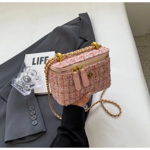 Detailed shot of pink tweed chain bag with camellia metal clasp and gold hardware