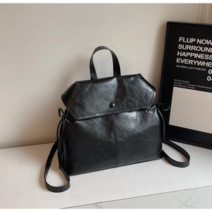 Detail of black vintage leather backpack showing lychee texture and bow drawstring