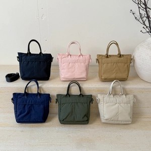 Mini nylon tote bags in six colors shown on a stone platform for autumn 2025 casual style