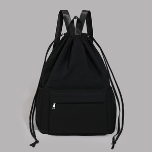 Detail of waterproof black drawstring backpack featuring a silver metal zipper front pocket