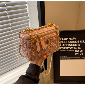 Detail of pink tweed texture and floral metal zipper on a classic chain bag